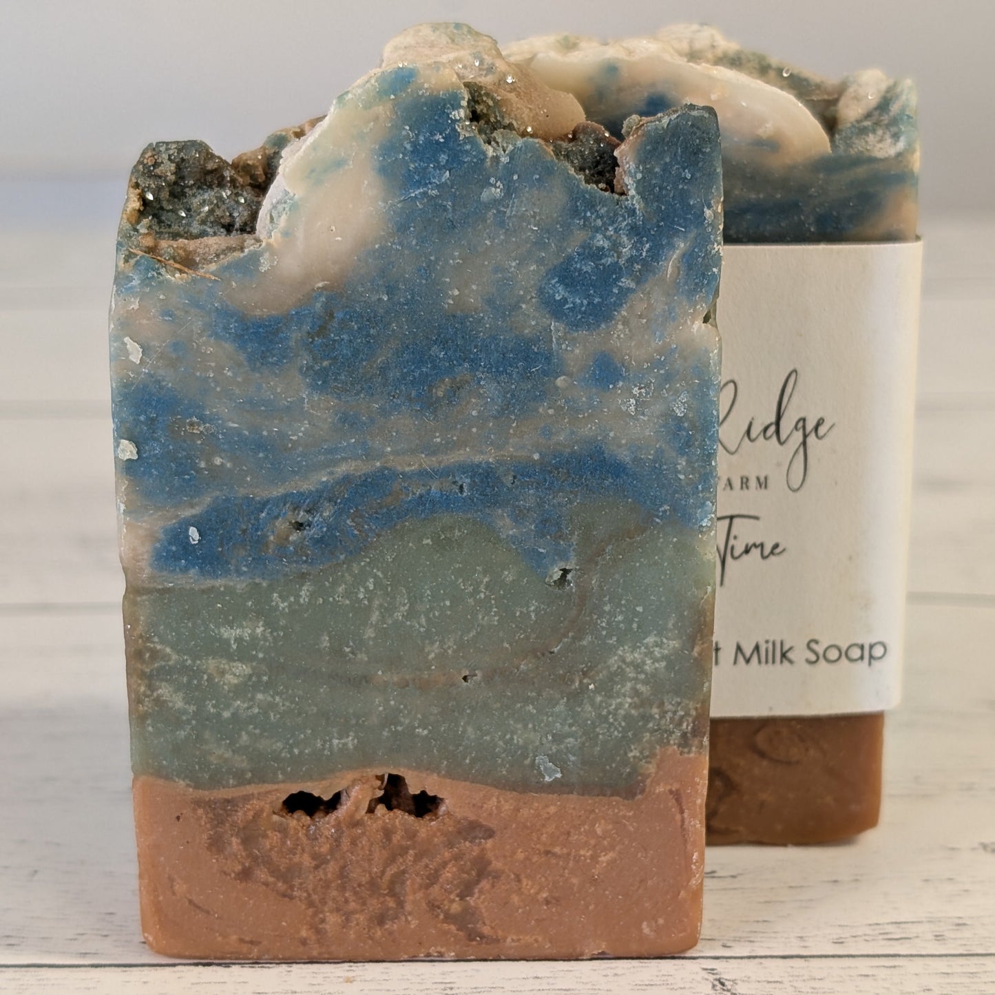 Handcrafted soap bar with natural coloration on a wooden surface