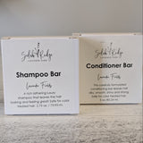 Two boxes of Shampoo Bar and Conditioner Bar from Selah & Ridge on a wooden surface.