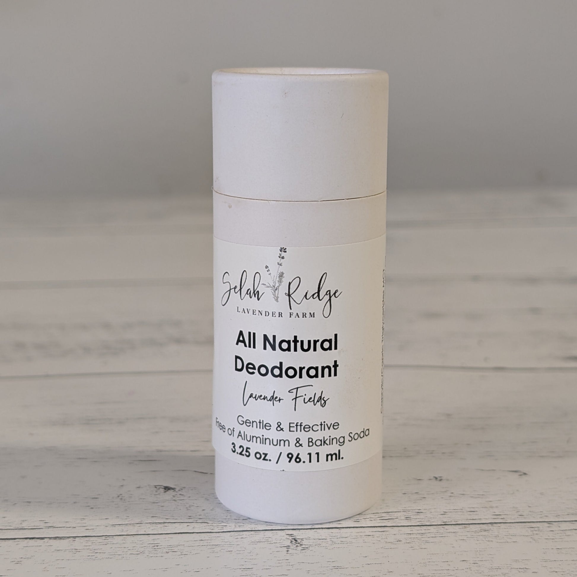 All natural deodorant bottle on a wooden surface with a gray background